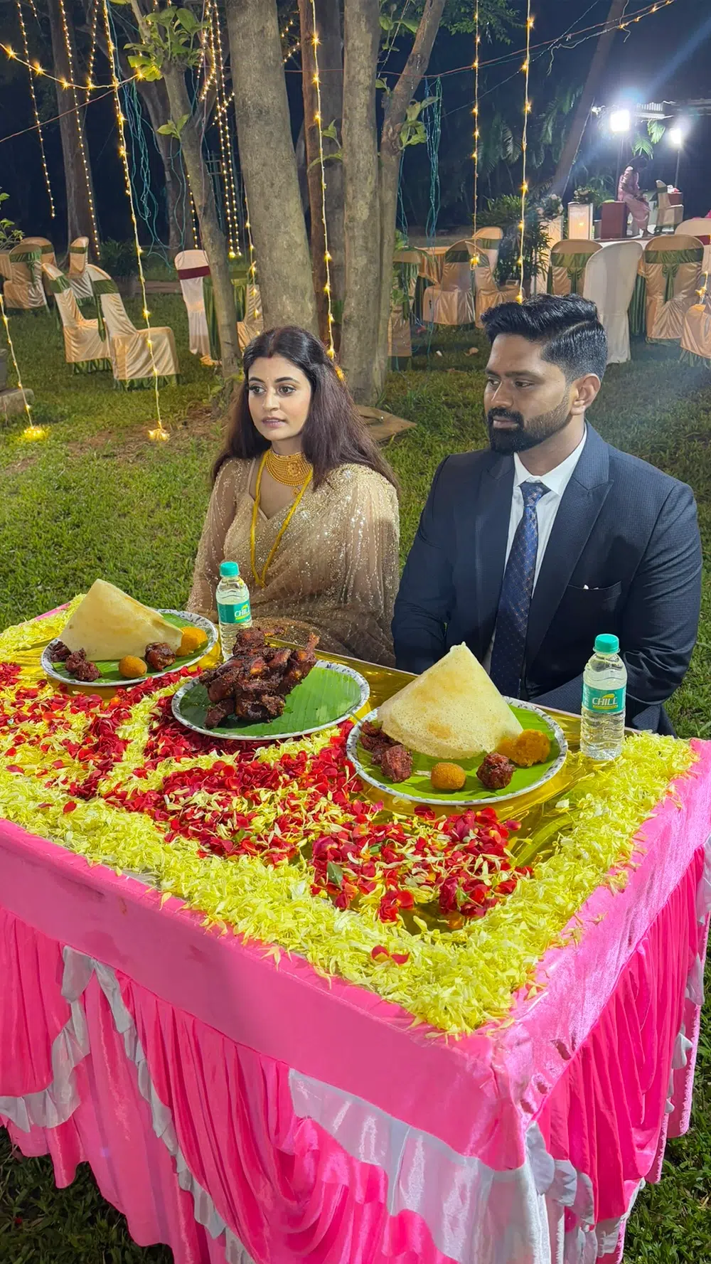 South Indian bride and groom enjoying hot cone dosas on banana leaves at a flower-decorated VIP table set up by My Chennai Catering Services in Chennai