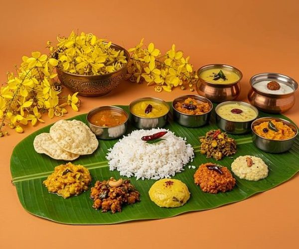 Authentic Tamil New Year feast served on a banana leaf featuring rice, sambar, rasam, poriyal, and festive dishes.